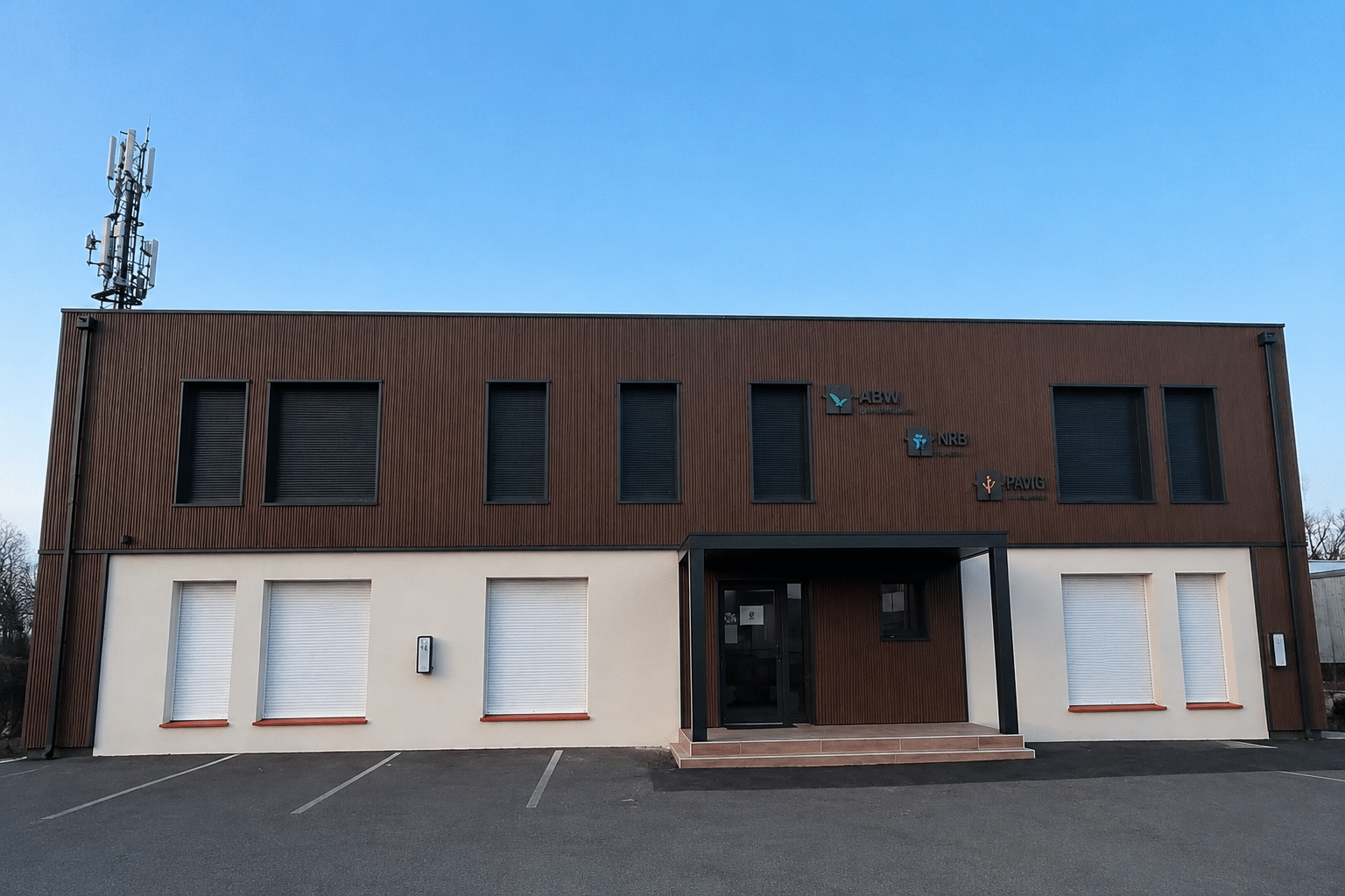 Bâtiment de bureaux ABW NRB PAVIG à façade bicolore, volets fermés et pylône de télécommunication sur le toit.