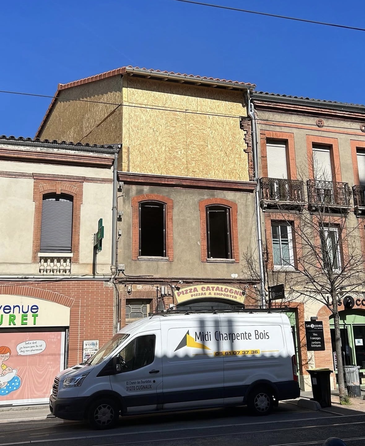 Camion Midi Charpente Bois devant une façade en panneaux OSB en rénovation.